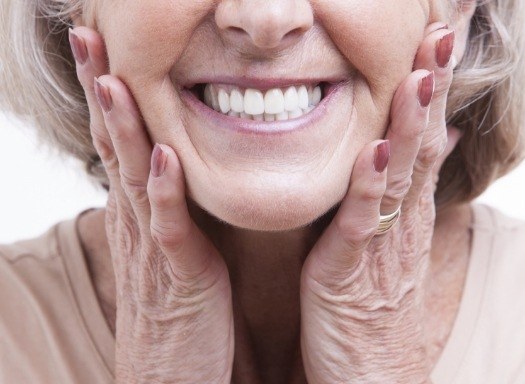 Smiling senior woman touching her face