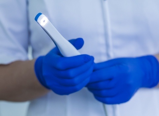 Dentist holding thin white intraoral camera