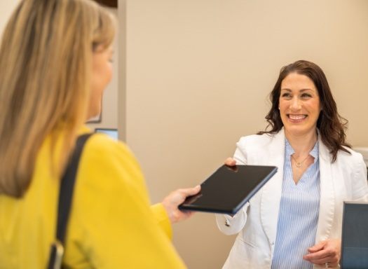 Dental team member handing tablet to a patient