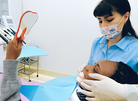 Dentist examining female patient’s mouth
