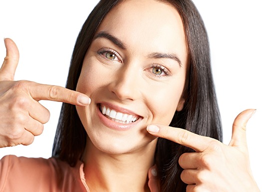 Smiling woman pointing to her teeth