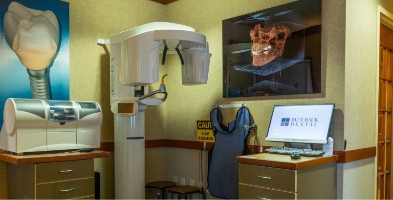 Dental x ray machine in corner next to computer