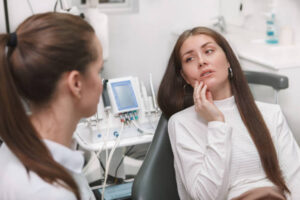 Young woman with a dental emergency in dentist’s chair