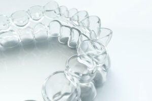 Clear aligners resting on a white-gray background